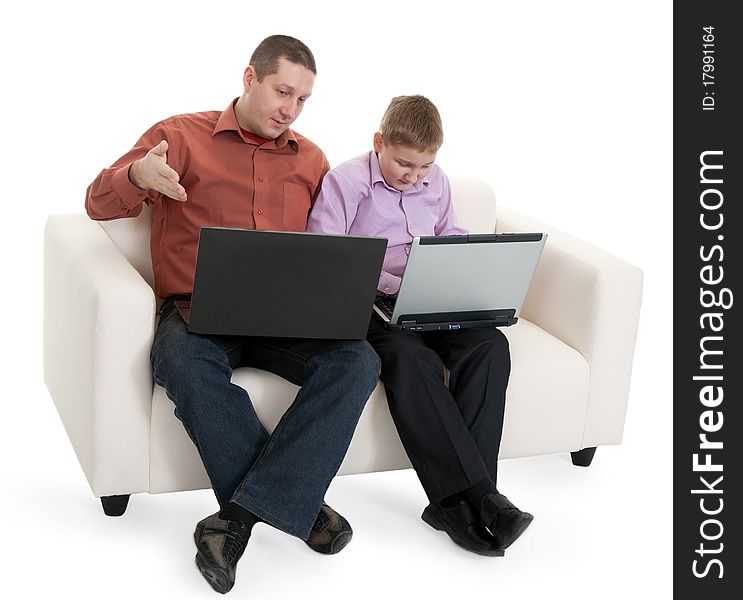 Father and son sitting on the couch with laptops