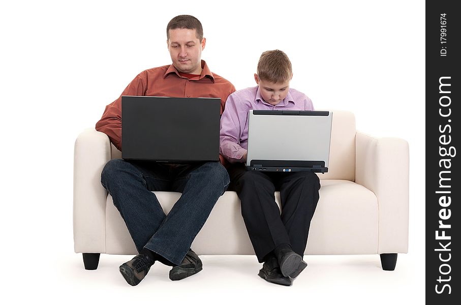 Father and son sitting on the couch with laptops