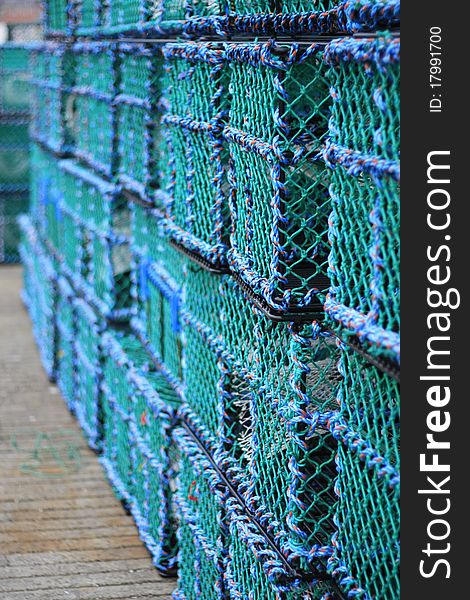 Lobster pots or creels as they are known in Scotland stacked on the harbour side. Lobster pots or creels as they are known in Scotland stacked on the harbour side