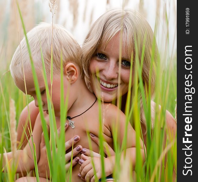 Happy mother and son in green grass