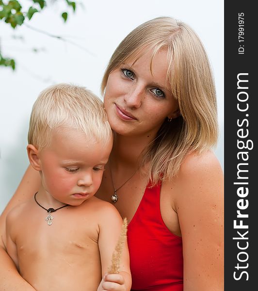 Portrait - mother with the small son against a summer garden