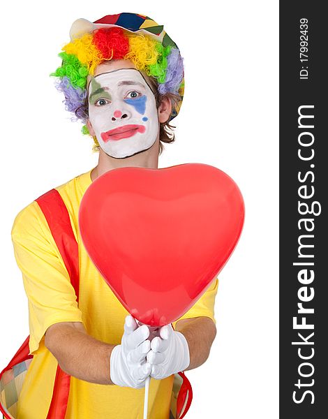 Young man in a clown's costume holding a heart-shaped balloon - isolated. Young man in a clown's costume holding a heart-shaped balloon - isolated