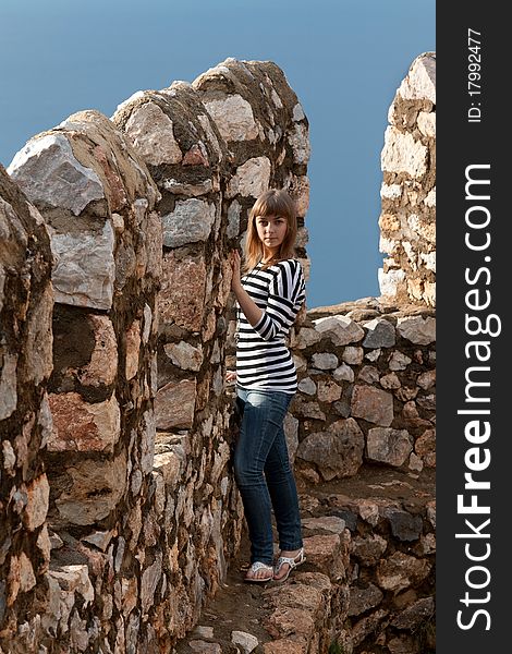 Beautiful girl on the wall of an old fortress