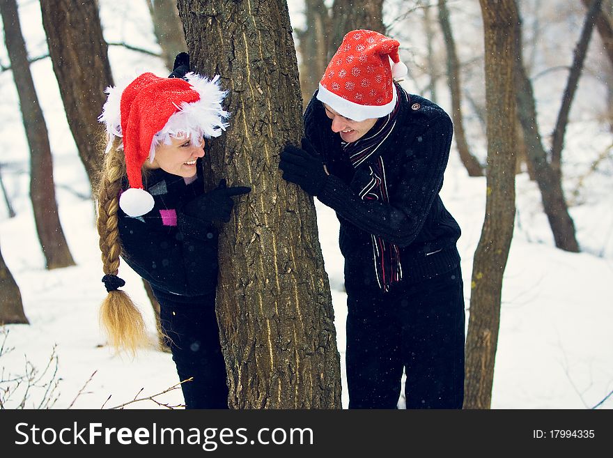 Lovers in Christmas hats, in the forest. Lovers in Christmas hats, in the forest