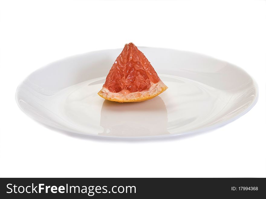 Grapefruit in a cut on a white plate