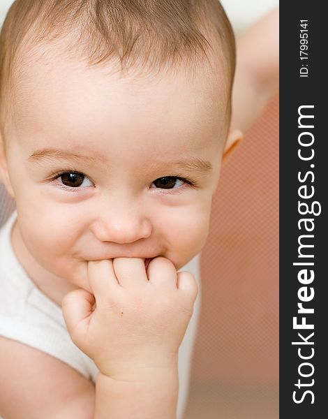 Fun caucasian baby with finger in his mouth, home play