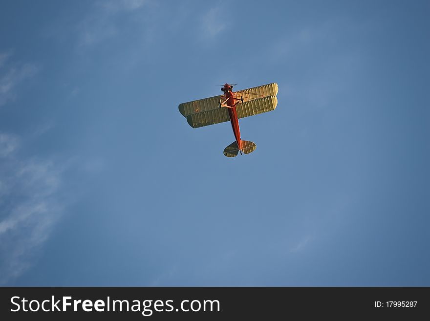 An open cockpit red student prince biplane in flight