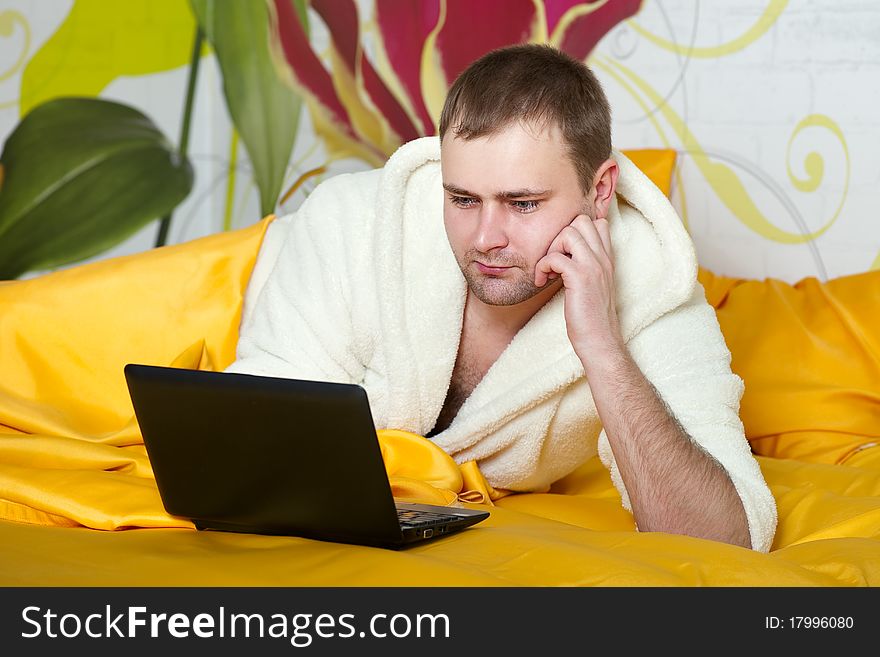 Portrait of a relaxed young guy using laptop beautiful