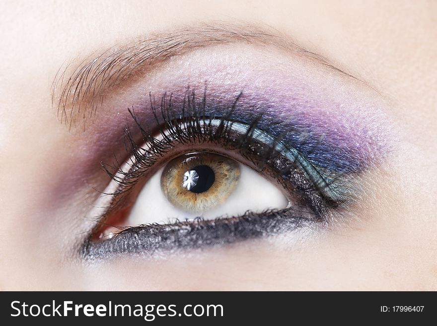 Macro shot of woman eye with violet and blue bright make-up. Macro shot of woman eye with violet and blue bright make-up