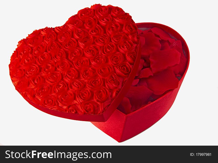 Opened red heart shaped box with rose petals inside it isolated on a white background. Opened red heart shaped box with rose petals inside it isolated on a white background