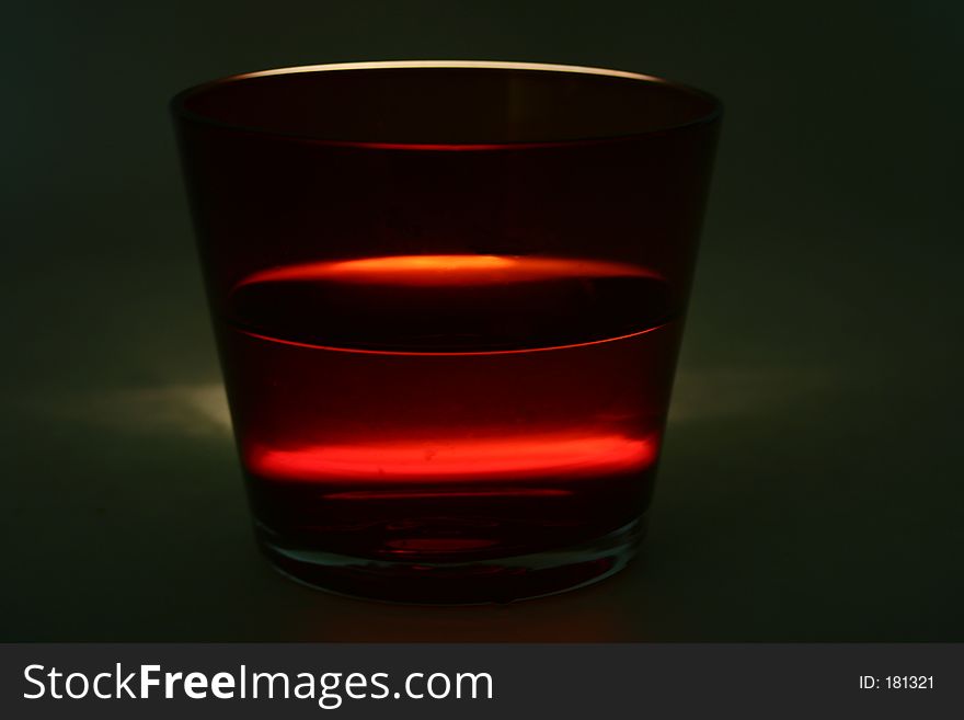 A red coloured glass shot in a lighting condition that has been specially created to make it dramatic. A red coloured glass shot in a lighting condition that has been specially created to make it dramatic