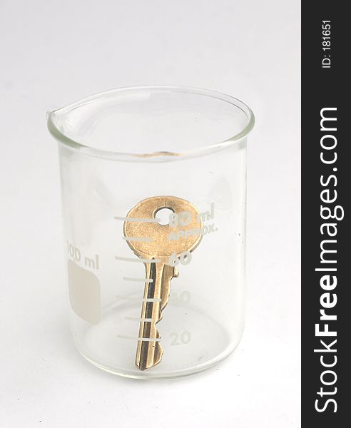 Brass key in scientific flask. Brass key in scientific flask