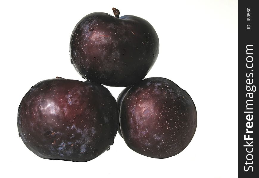 Three purple plums on white background