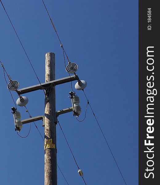 Power lines and pole isolated against blue sky. Power lines and pole isolated against blue sky