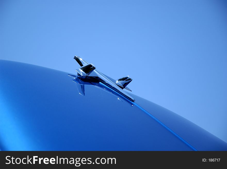Car ornament on open hood pointing to the sky
