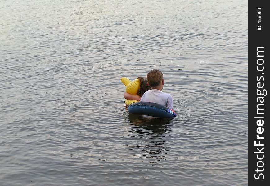 @ small children in a lake with their floaties. @ small children in a lake with their floaties.