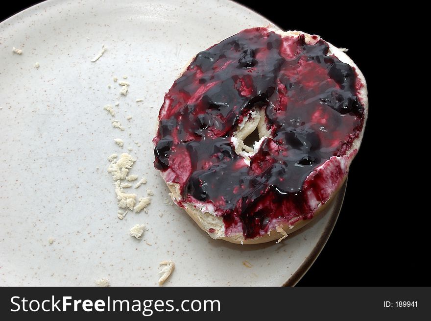 The last bagel half, covered in cheese and jelly. The last bagel half, covered in cheese and jelly