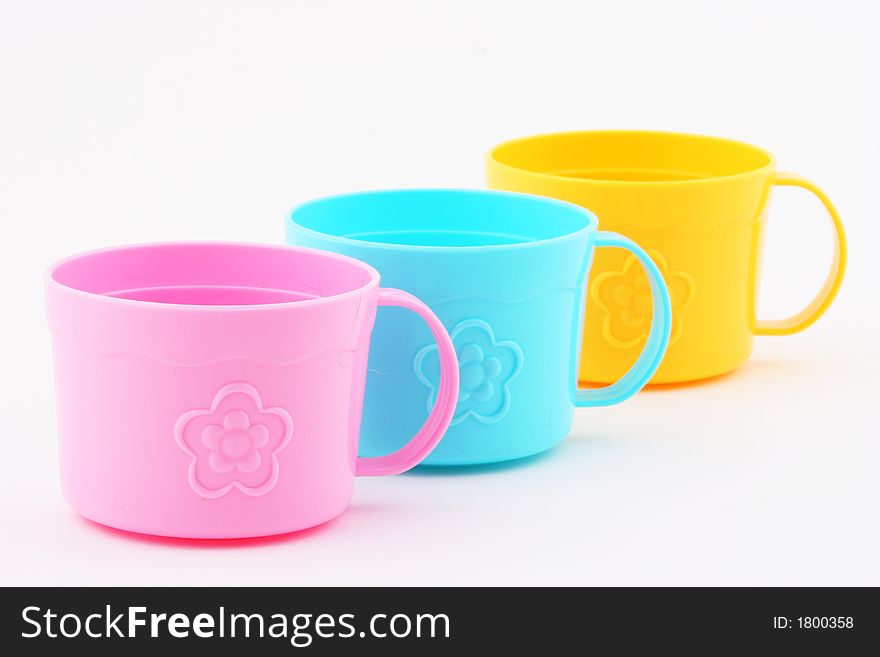 A diagonal line of three toy tea cups