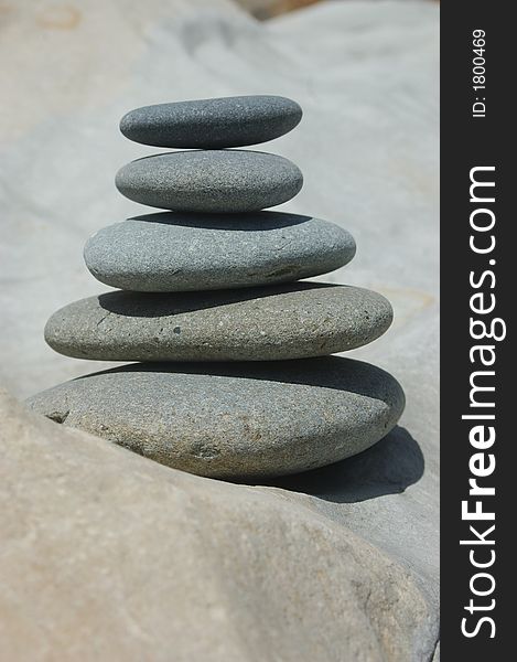 Smooth stones stacked up on a smooth rock. Smooth stones stacked up on a smooth rock