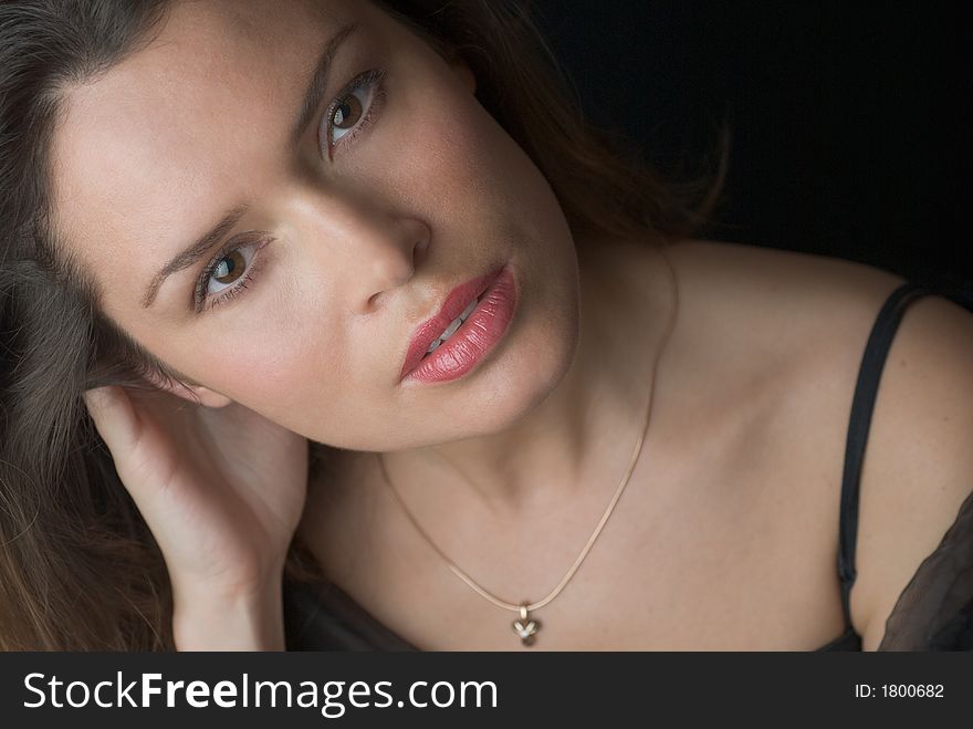 Beautiful brunette portrait over dark background. Beautiful brunette portrait over dark background