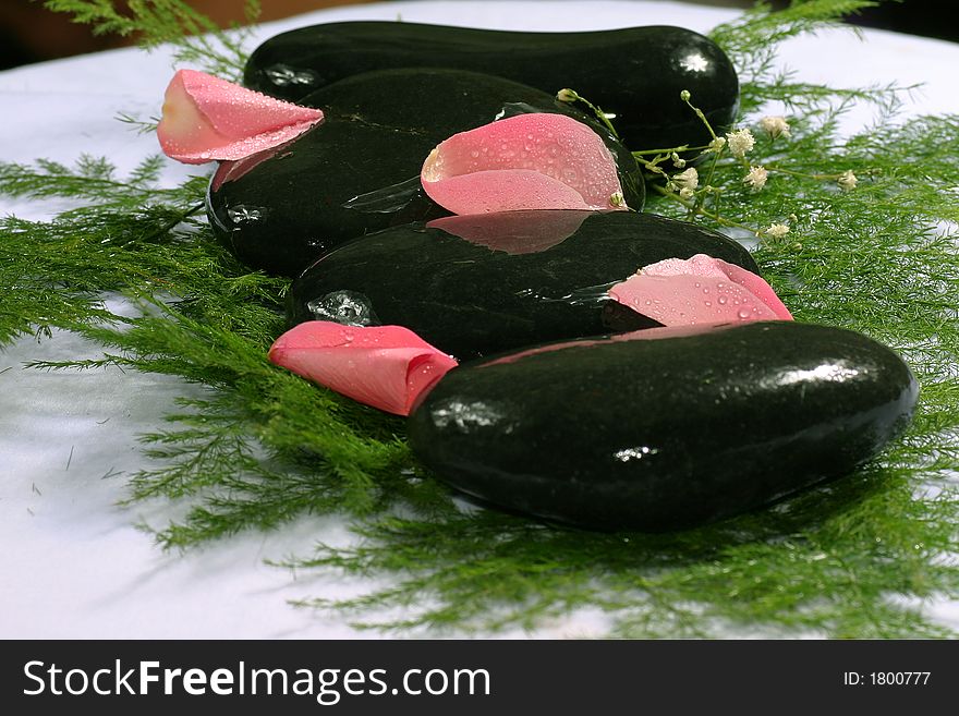 Nice and fresh pink rose petal and natural pebbles on the flower background. Suitable for spa and relaxation setting. Nice and fresh pink rose petal and natural pebbles on the flower background. Suitable for spa and relaxation setting.