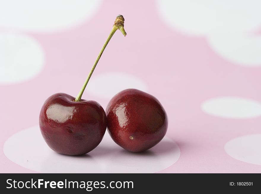 2 cherries on pink polka dot background.  Adobe RGB (1998), colour managed throughout.  Left the image unsharpened so buyer has max control