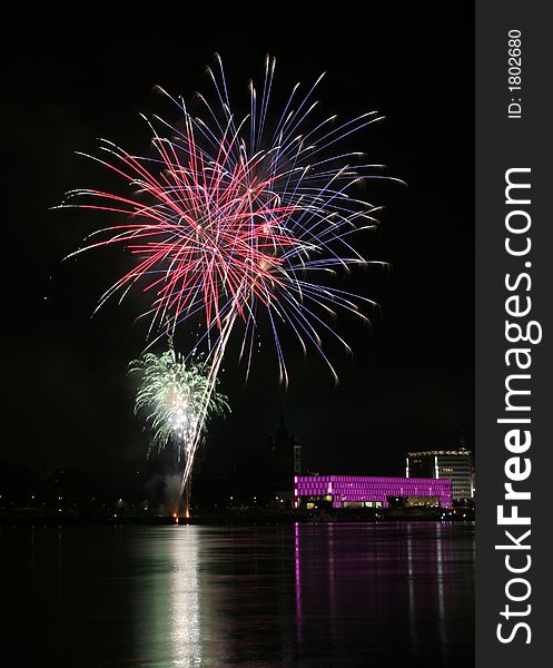 Fireworks in Linz (Austria) at the Danube river with beautiful reflections. On the right side the Brucknerhaus (orchestra house) on the left the Lentos (Museum) with its illuminated walls. Fireworks in Linz (Austria) at the Danube river with beautiful reflections. On the right side the Brucknerhaus (orchestra house) on the left the Lentos (Museum) with its illuminated walls.