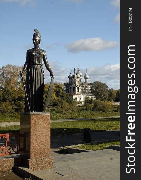 Women`s statue and chucrh on the river. Vologda, Russia.
