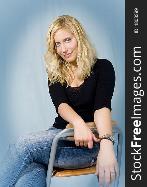 Portrait of a blond woman sitting on a chair. Portrait of a blond woman sitting on a chair