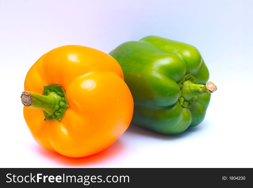 Yellow and green bell peppers on multicolored background