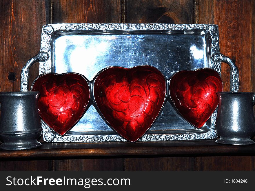 Three red Hearts tray displayed for Valentines against a pewter tray and mugs. Three red Hearts tray displayed for Valentines against a pewter tray and mugs.