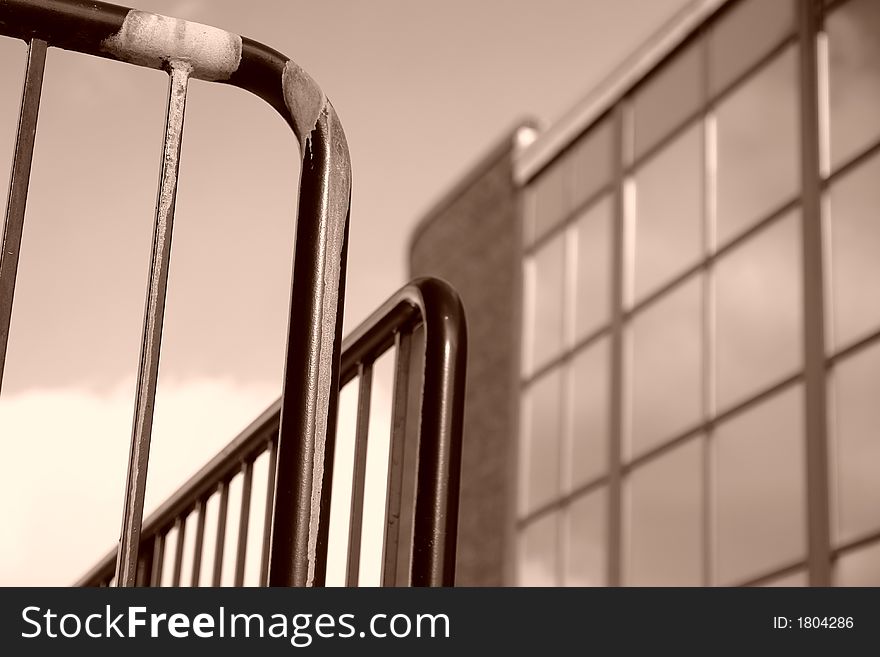 Sepia toned image of iron railing with building in background. Sepia toned image of iron railing with building in background
