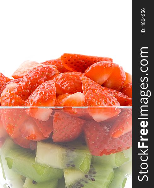 Red and green, strawberry with kiwi in transparent bowl on white background. Isolated