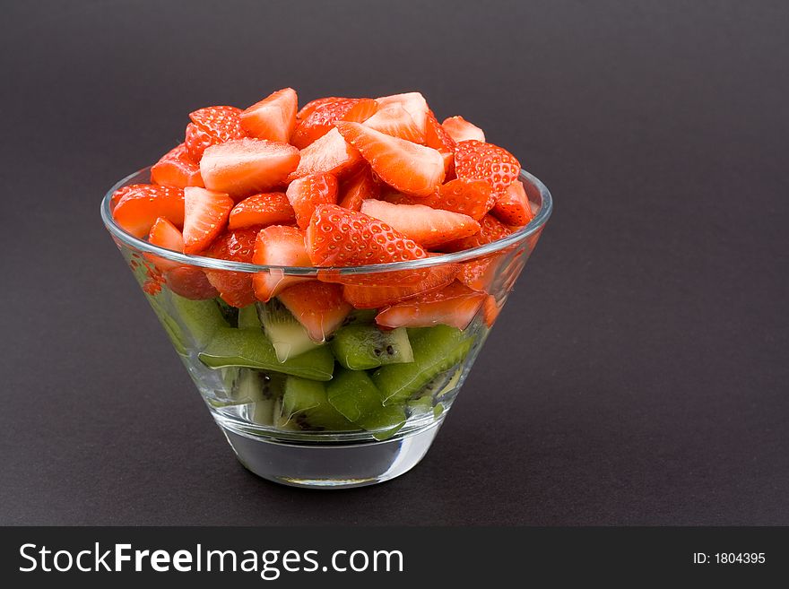 Strawberries With Kiwi In Transparent Bowl On Dark Background