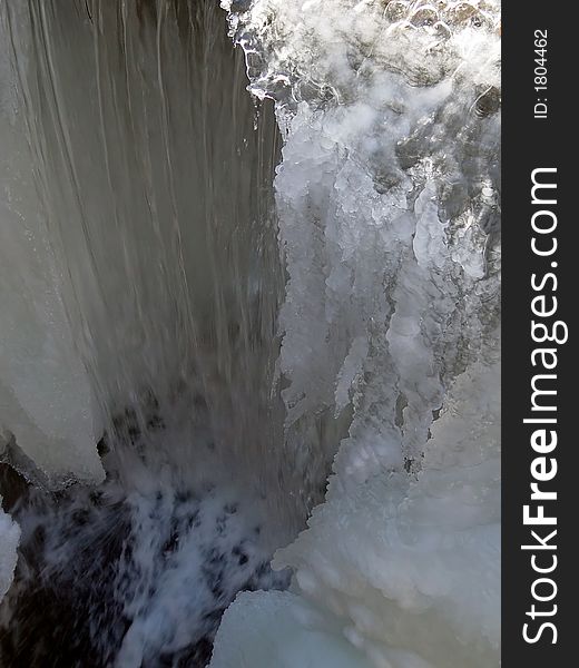 Large section of snow and ice above  flowing water. Large section of snow and ice above  flowing water