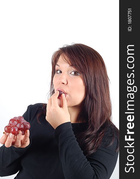 Attractive woman eating grapes on white background. Attractive woman eating grapes on white background