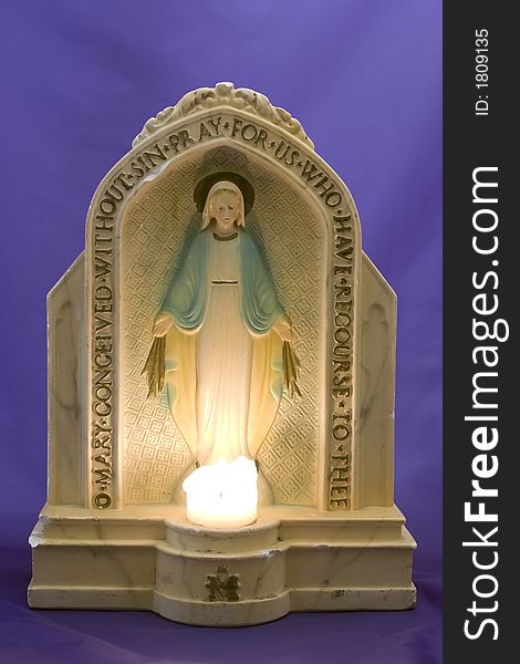 Antique statuette of the Virgin Mary with lit candle. Antique statuette of the Virgin Mary with lit candle.