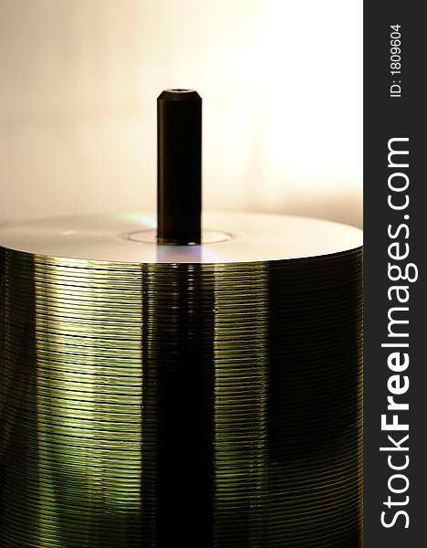 A back lit spindle of translucent cds. A back lit spindle of translucent cds.