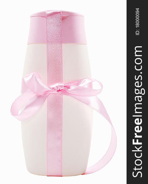 White bottle of shampoon with pink cap and pink ribbon for a present. White bottle of shampoon with pink cap and pink ribbon for a present.