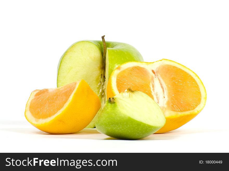 Slices of apple and orange on the background of the cut fruits