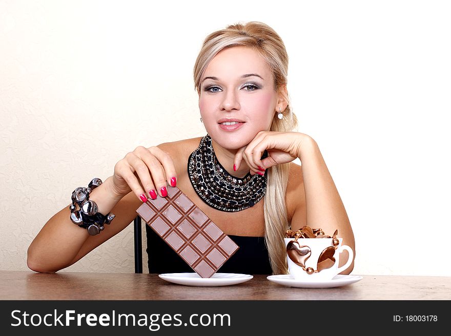 Woman with cup of chocolate against yellow wall at table