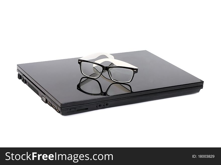 Laptop with vintage glasses isolated on white background