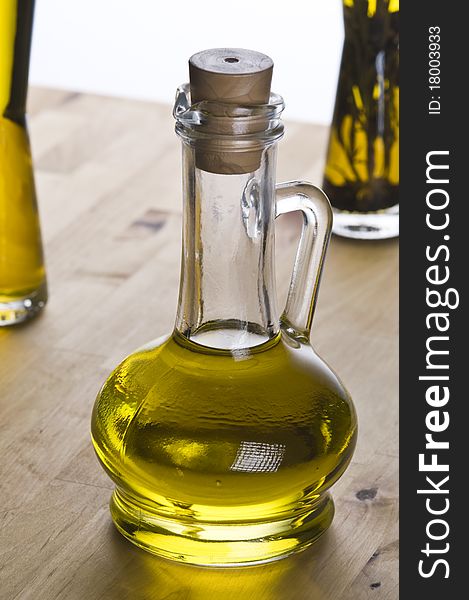 Olive oil bottle still-life over light  background, focus on foreground. Olive oil bottle still-life over light  background, focus on foreground