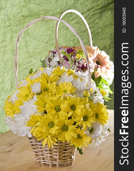 Flowers in a basket over green textured background. Flowers in a basket over green textured background