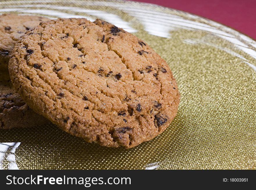 Chocolate cookies on a plate over color background