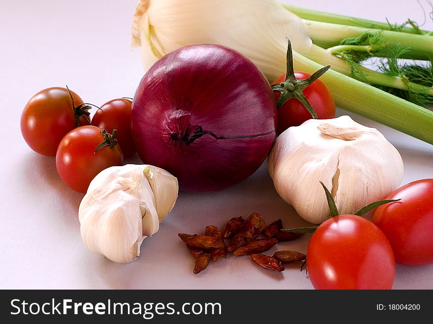 Tomatoes, garlic, onion, fennel and pepper with grey background. Tomatoes, garlic, onion, fennel and pepper with grey background