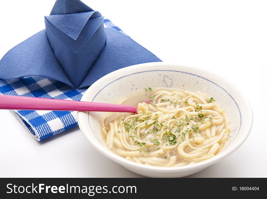 Plate with noodle soup and napkin