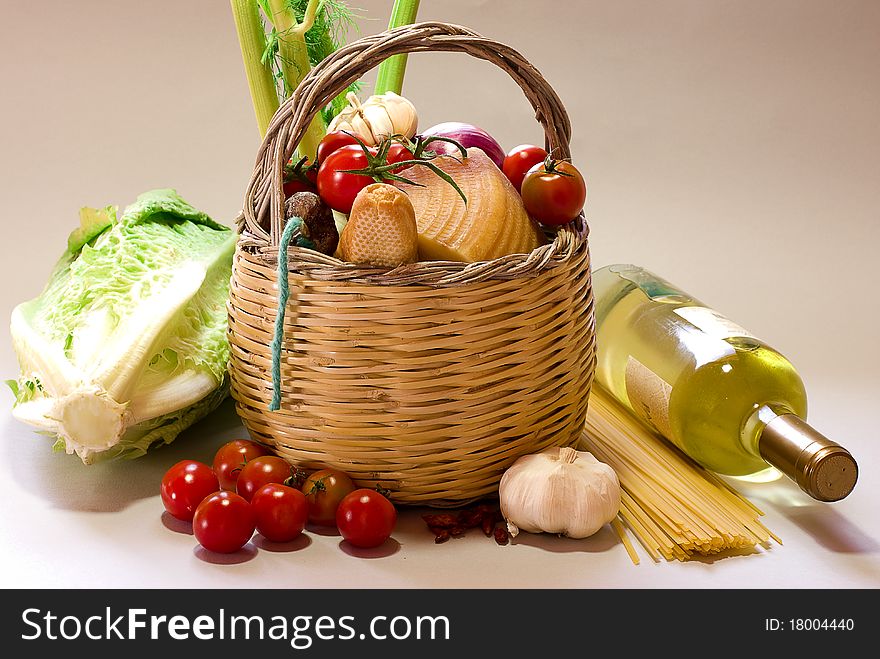 Basket with vegetables and vine with grey background. Basket with vegetables and vine with grey background