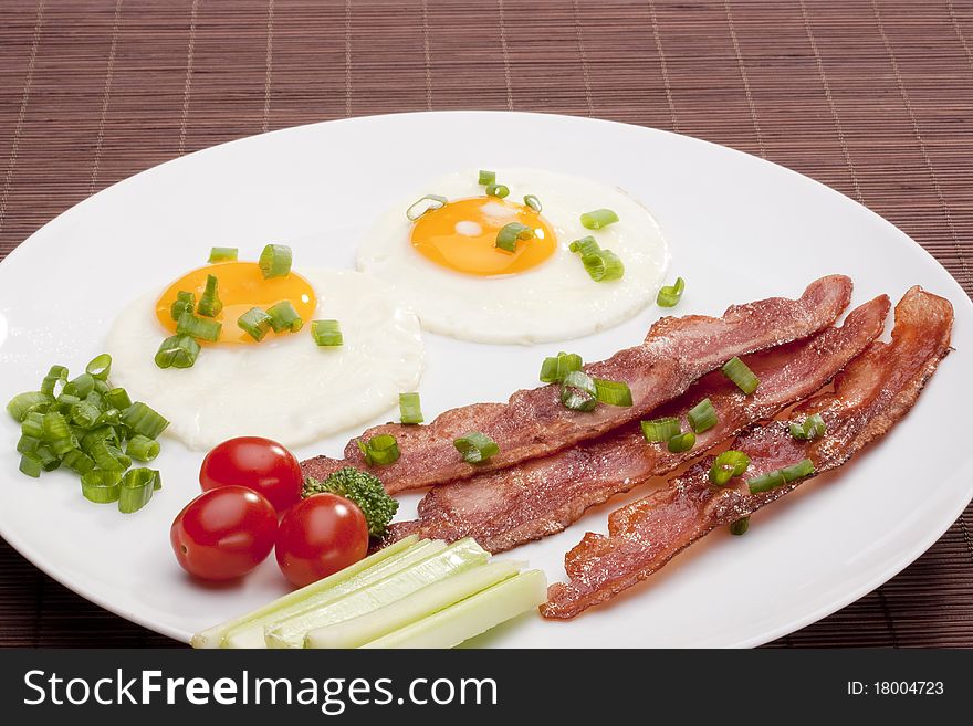 Grilled thinly sliced bacon with eggs and vegetables.