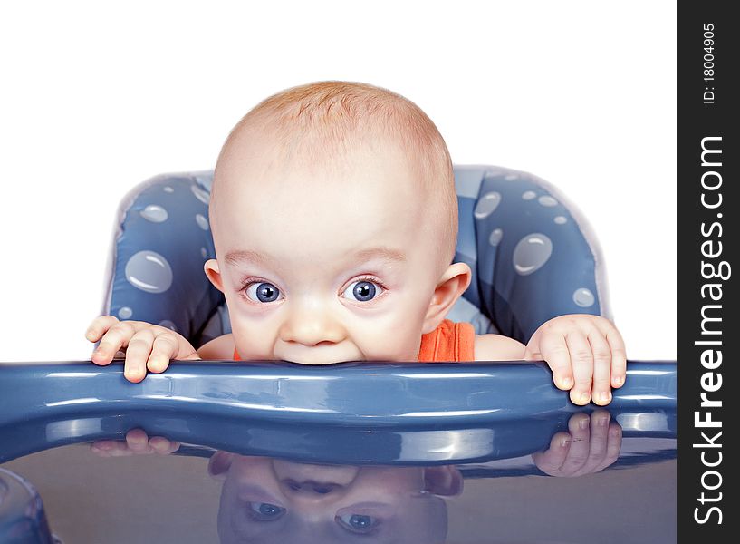 Small beautiful baby boy in a baby chair on a white background